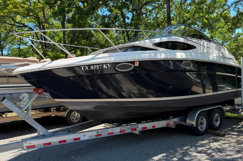 The Image of 2008 Regal 2565 Window Express boat on trailer, parked outdoors with trees in background. - 1