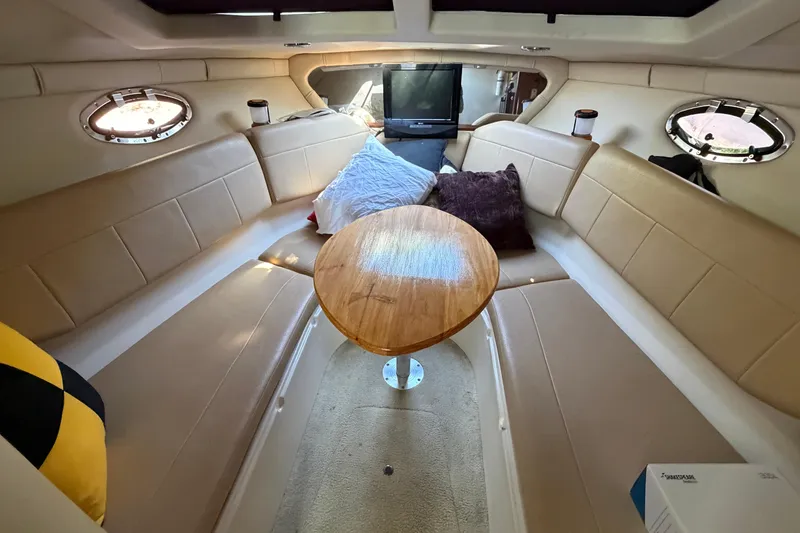 Slide: The Image of Interior of 2008 Regal 2565 Window Express boat with cozy seating and wooden table. - 17