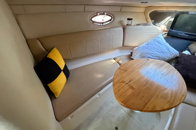 Slide: The Image of Interior of a 2008 Regal 2565 Window Express boat with seating and a wooden table. - 18