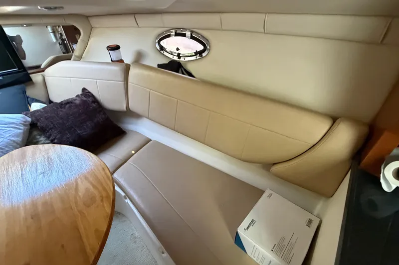 Slide: The Image of Interior of 2008 Regal 2565 Window Express boat with beige seating and wooden table. - 19