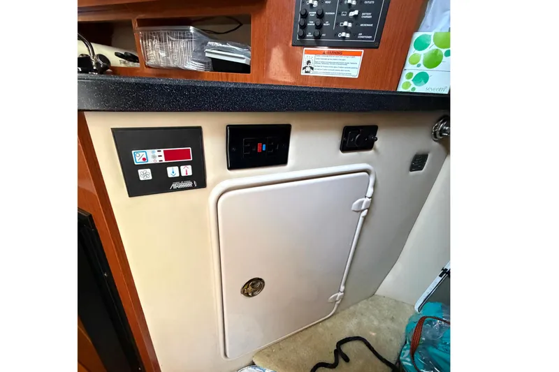 Slide: The Image of 2008 Regal 2565 Window Express cabin interior with control panel and storage compartment. - 22