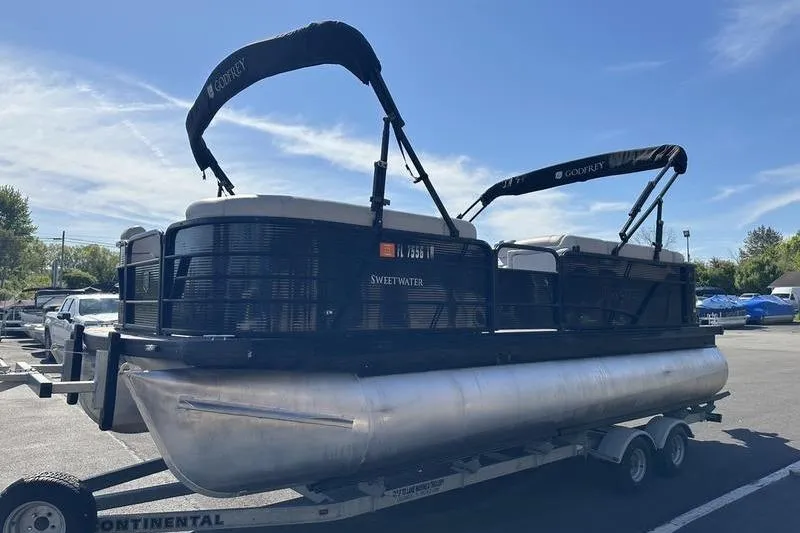 The Image of 2022 Godfrey Sweetwater 2186 C4 pontoon boat on trailer under clear blue sky. - 0