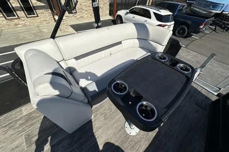 Slide: The Image of 2022 Godfrey Sweetwater 2186 C4 boat interior with seating and table, parked outdoors. - 25