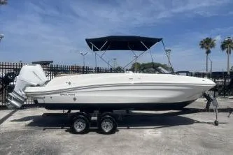 The Image of 2022 Bayliner VR6 Bowrider OB on trailer, white hull, outdoor setting, clear sky. - 1