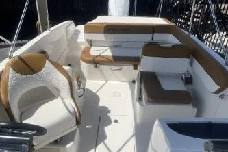 Slide: The Image of 2022 Bayliner VR6 Bowrider OB interior with white and brown seating arrangement. - 10