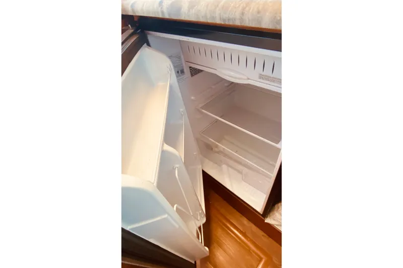 Slide: The Image of Open refrigerator inside 1986 Ocean Yachts 48 Super Sport, showcasing interior storage space. - 11