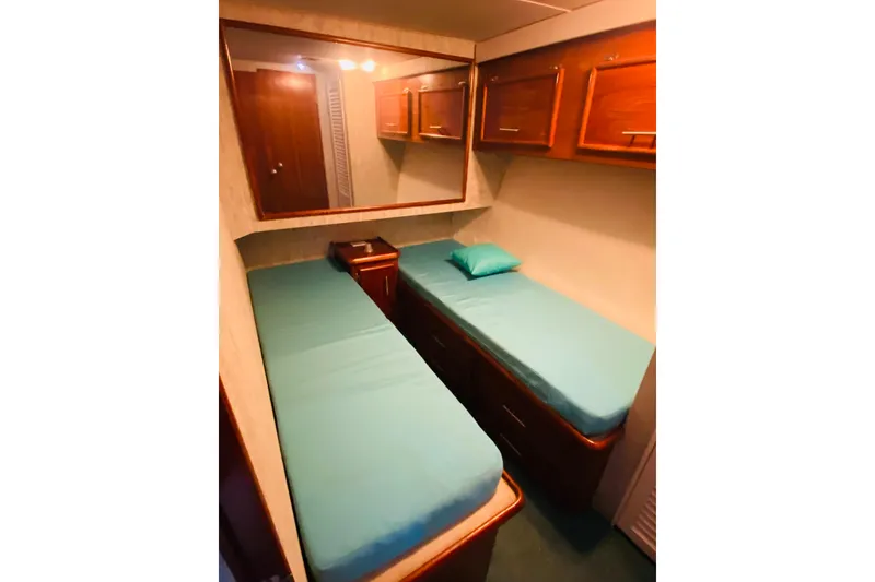 Slide: The Image of Port side cabin of 1986 Ocean Yachts 48 Super Sport with twin beds and wooden cabinetry. - 16