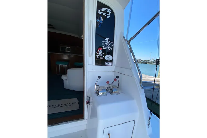 Slide: The Image of 1986 Ocean Yachts 48 Super Sport boat interior with control levers and nautical stickers. - 7