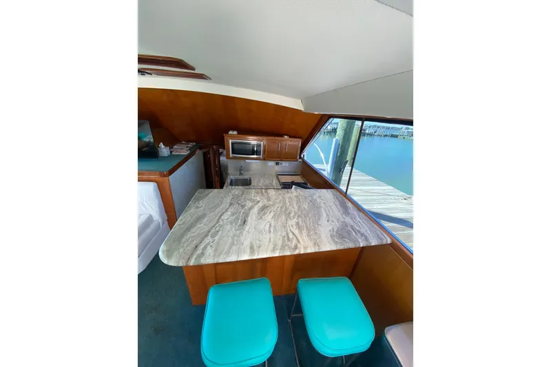 Slide: The Image of Interior of 1986 Ocean Yachts 48 Super Sport with marble countertop and turquoise stools. - 8
