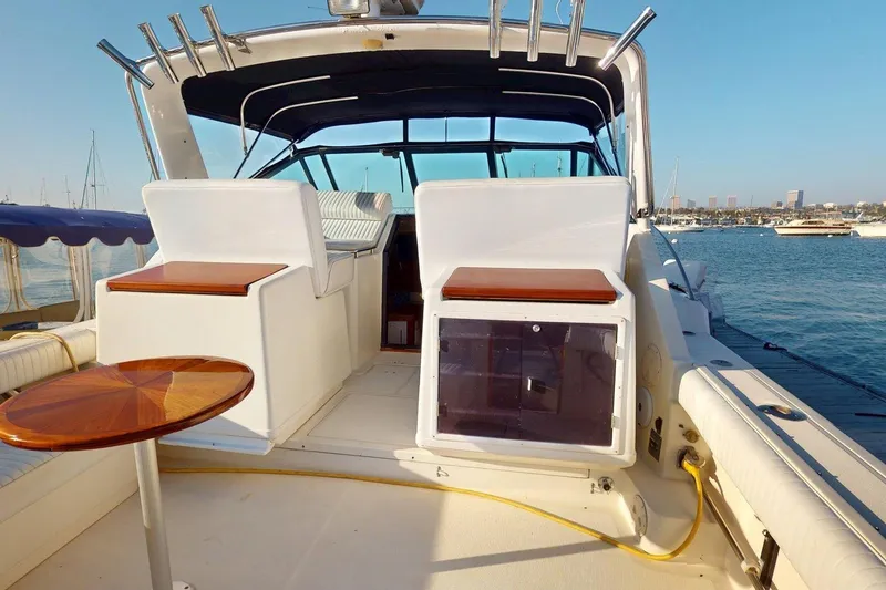 Slide: The Image of 1989 Tiara 3300 Open yacht interior with seating and table, docked in a marina. - 13