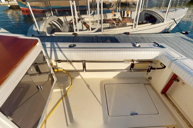 Slide: The Image of 1989 Tiara 3300 Open boat interior at dock, featuring seating and storage areas. - 15