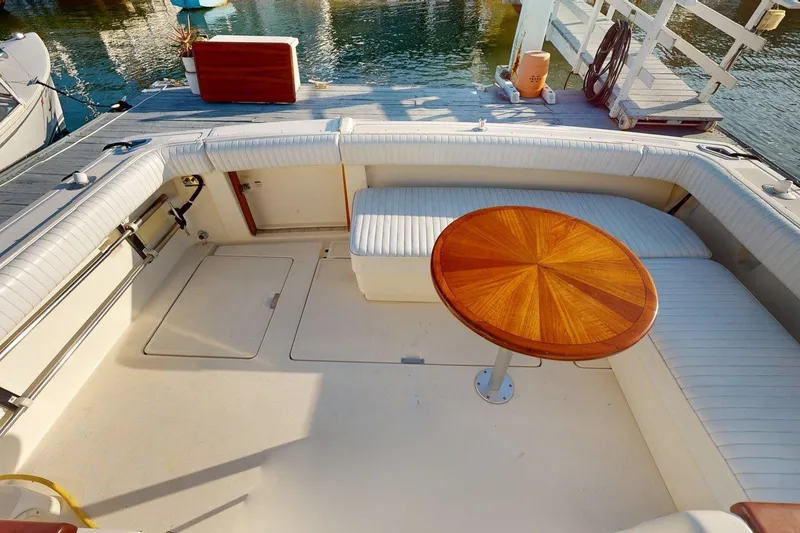Slide: The Image of 1989 Tiara 3300 Open boat deck with cushioned seating and wooden table. - 17