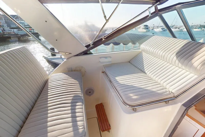 Slide: The Image of 1989 Tiara 3300 Open boat interior with white cushioned seating and waterfront view. - 20
