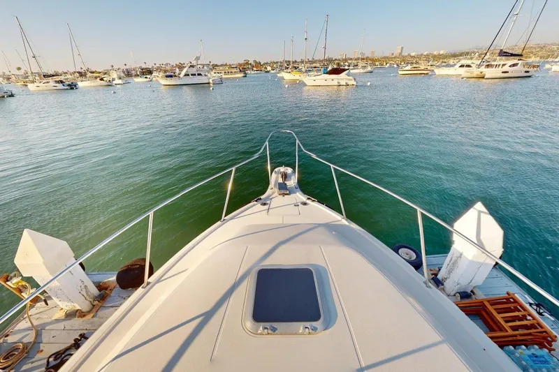 Slide: The Image of Bow view of 1989 Tiara 3300 Open yacht in a marina with calm waters. - 25