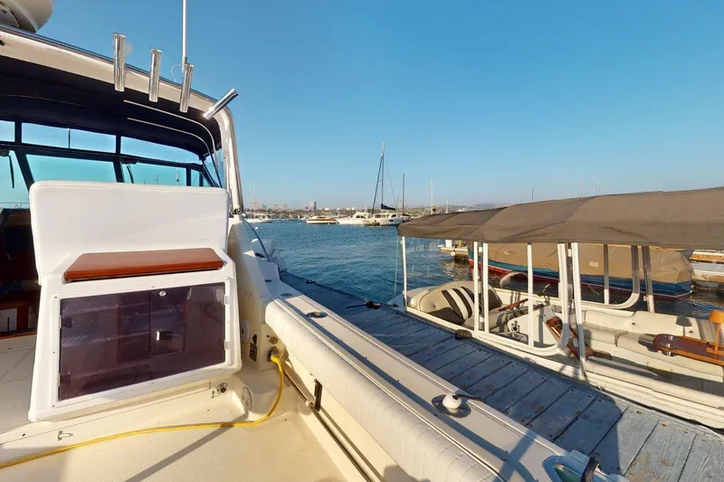 Slide: The Image of 1989 Tiara 3300 Open yacht docked at marina, clear blue sky, calm waters. - 30