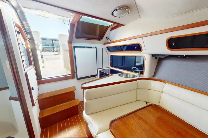 Slide: The Image of Interior of a 1989 Tiara 3300 Open yacht with wood accents and white seating. - 4