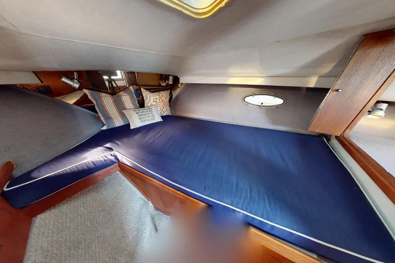 Slide: The Image of Interior cabin of 1989 Tiara 3300 Open boat with blue cushions and decorative pillows. - 5