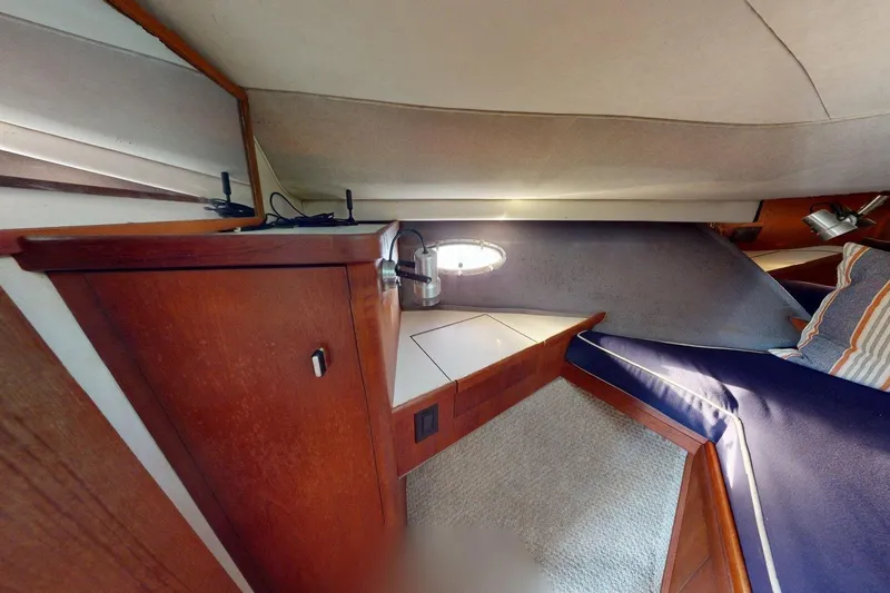Slide: The Image of Interior cabin of a 1989 Tiara 3300 Open yacht with wood cabinetry and blue cushions. - 6