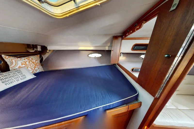Slide: The Image of 1989 Tiara 3300 Open cabin interior with blue bedding and decorative pillows. - 8