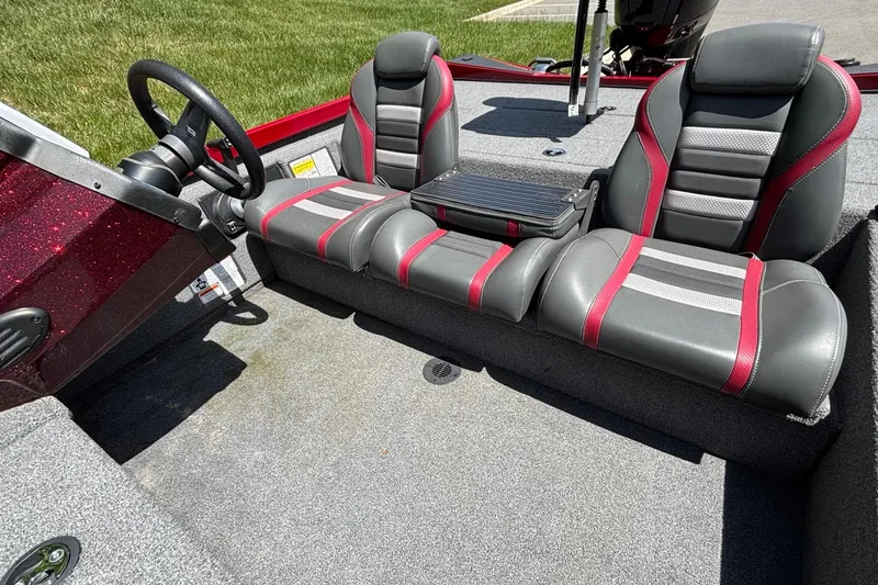 Slide: The Image of 2024 Ranger RT188 boat interior with gray and red seating, steering wheel, and carpeted floor. - 10