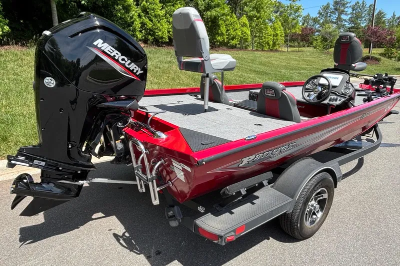 Slide: The Image of 2024 Ranger RT188 boat with Mercury engine, red exterior, and trailer on a sunny day. - 16