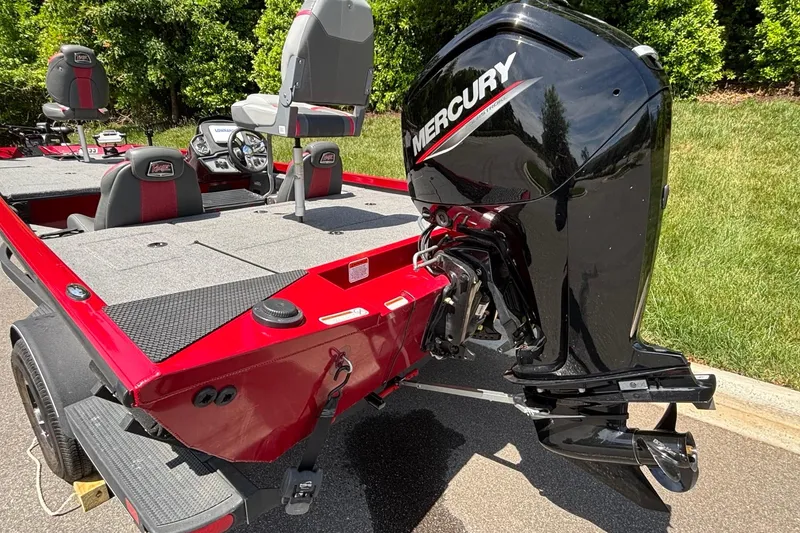 Slide: The Image of 2024 Ranger RT188 boat with Mercury outboard motor, red and gray interior, parked outdoors. - 17