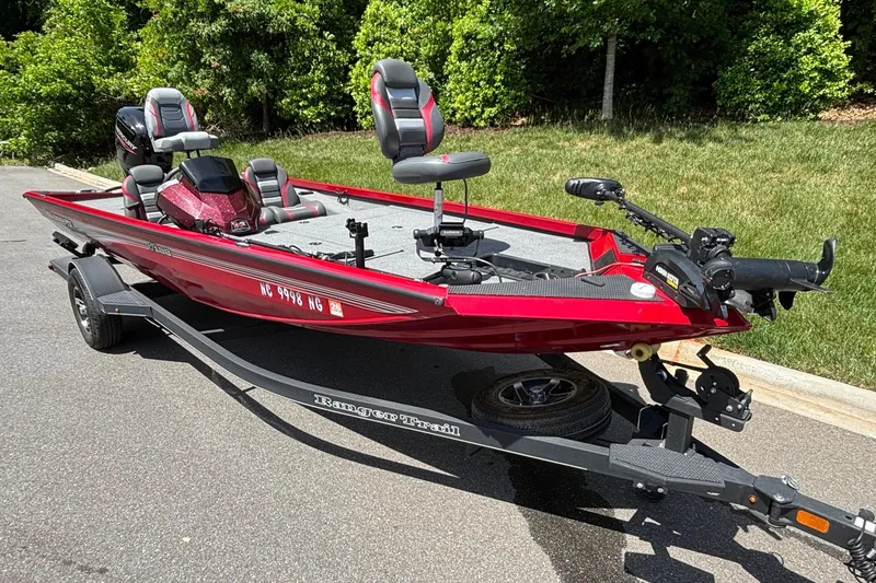 Slide: The Image of 2024 Ranger RT188 boat in vibrant red on a trailer, parked outdoors. - 5