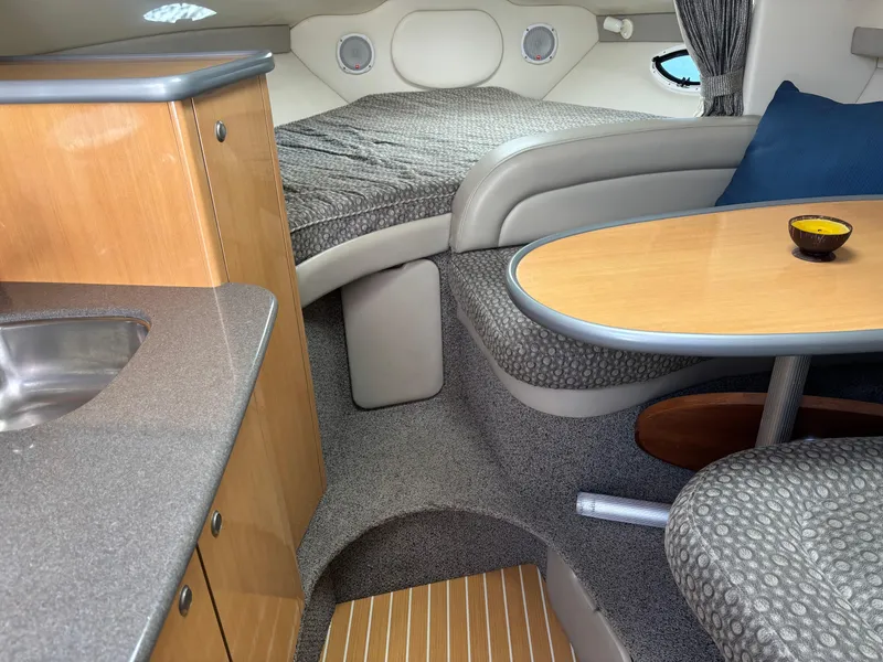 Slide: The Image of 2004 Maxum 2900 SCR cabin interior with bed, table, and kitchenette. - 14