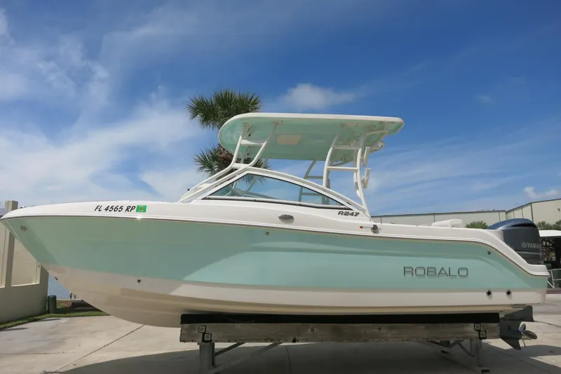The Image of 2018 Robalo R247 Dual Console boat on display, featuring sleek design and light blue hull. - 0