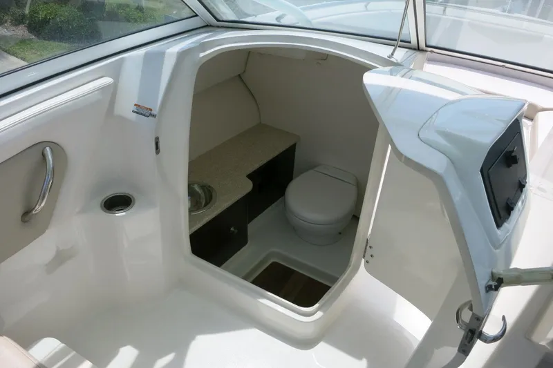 Slide: The Image of 2018 Robalo R247 Dual Console boat interior with compact bathroom and sink. - 14