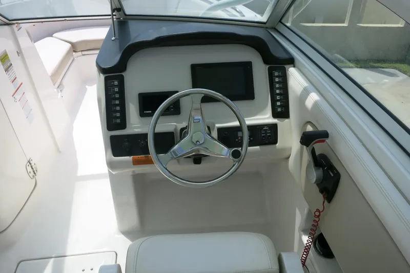 Slide: The Image of 2018 Robalo R247 Dual Console boat cockpit with steering wheel and control panel. - 15