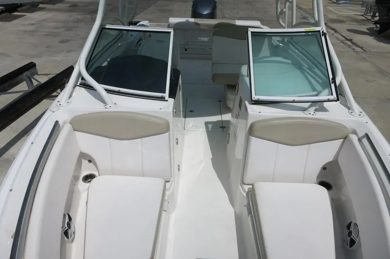 Slide: The Image of 2018 Robalo R247 Dual Console boat interior with seating and open windshield. - 19