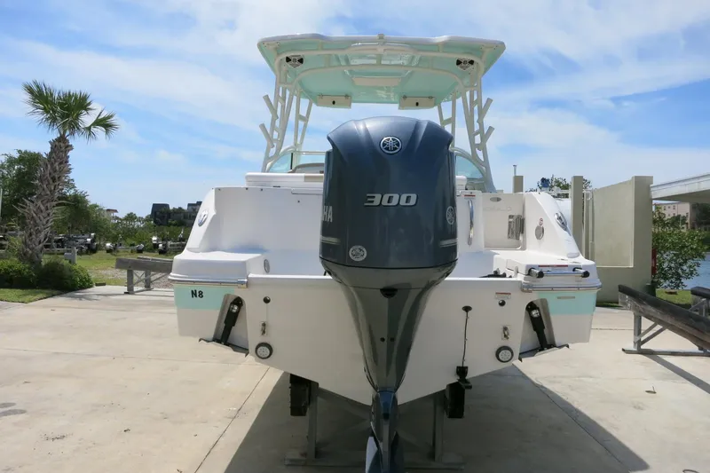 Slide: The Image of 2018 Robalo R247 Dual Console boat with Yamaha 300 engine, docked outdoors. - 2