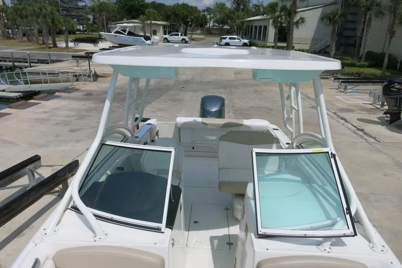 Slide: The Image of 2018 Robalo R247 Dual Console boat docked, showcasing spacious seating and sleek design. - 20