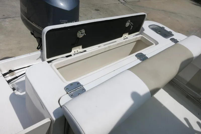 Slide: The Image of 2018 Robalo R247 Dual Console boat with open storage compartment and Yamaha engine. - 24