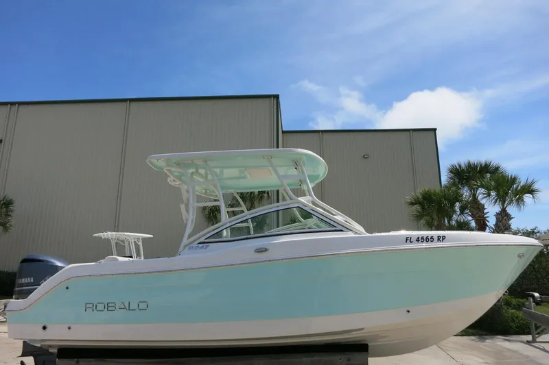 Slide: The Image of 2018 Robalo R247 Dual Console boat with Yamaha engine, parked outdoors. - 3