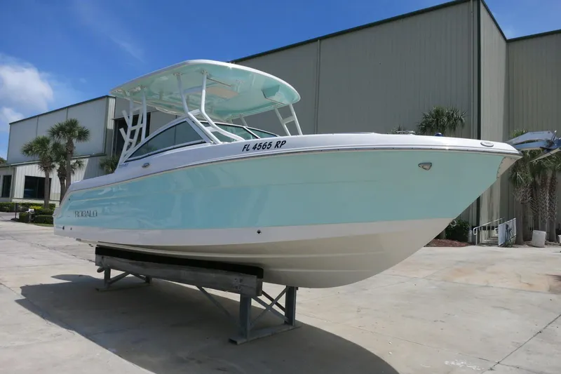 Slide: The Image of 2018 Robalo R247 Dual Console boat on display, light blue hull, outdoor setting. - 4