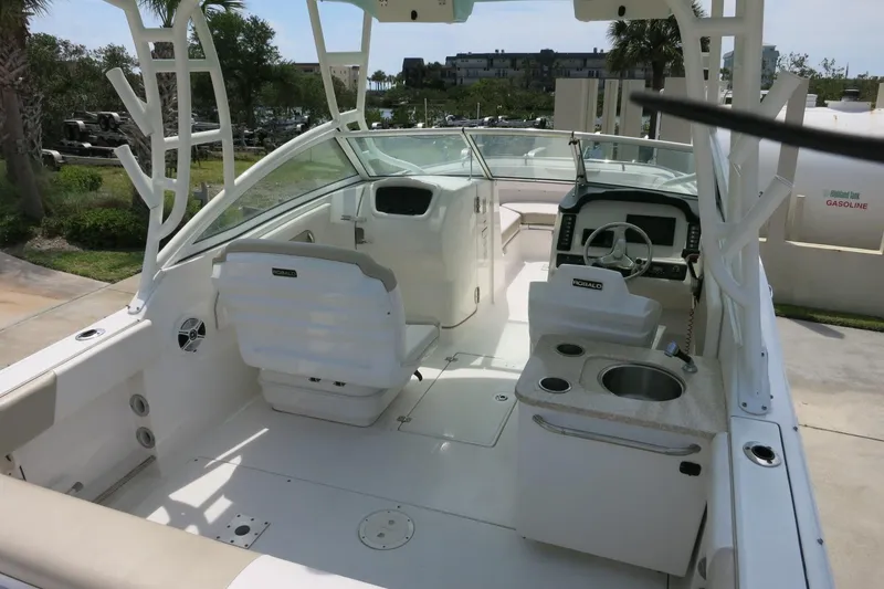 Slide: The Image of 2018 Robalo R247 Dual Console boat interior with seating, steering wheel, and sink. - 8