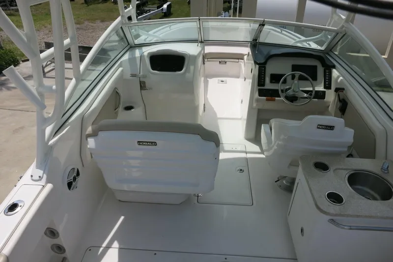 Slide: The Image of 2018 Robalo R247 Dual Console boat interior with helm, seating, and sink. - 9