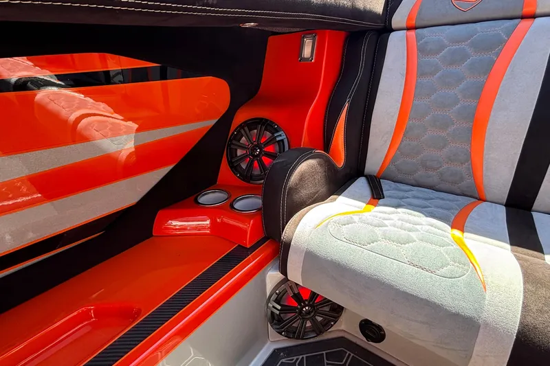 Slide: The Image of 2020 Eliminator 36 Daytona Coupe interior with vibrant orange and gray upholstery, featuring speakers and cup holders. - 21