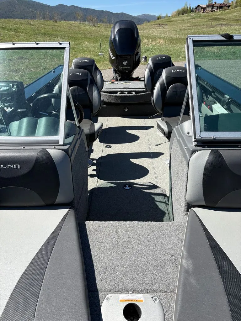 Slide: The Image of Interior view of a 2017 Lund 1875 Crossover XS boat on a field. - 2