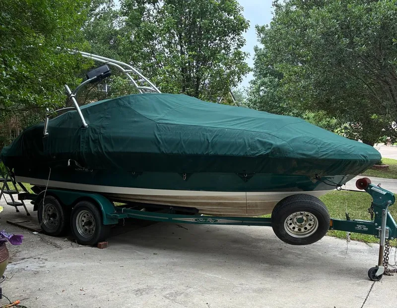 Slide: The Image of 2005 Sea Ray 200 Sundeck boat with cover on trailer. - 13