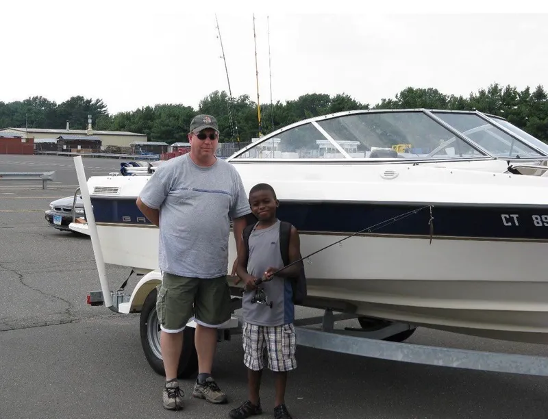 Slide: The Image of Two people beside a 2003 Bayliner 195 Bowrider boat. - 11