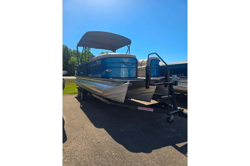 The Image of 2018 Manitou 23 Encore SL pontoon boat on trailer under clear blue sky. - 1