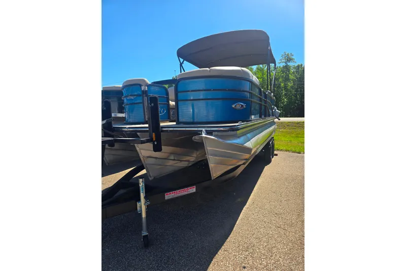 Slide: The Image of 2018 Manitou 23 Encore SL pontoon boat with blue exterior, parked on a sunny day. - 13