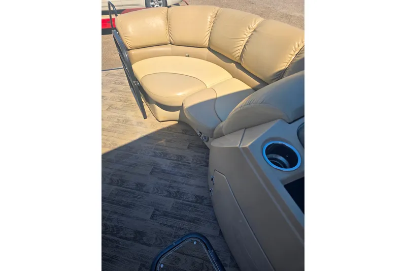 Slide: The Image of Luxurious seating on 2018 Manitou 23 Encore SL pontoon boat with cup holders and wood-style flooring. - 7