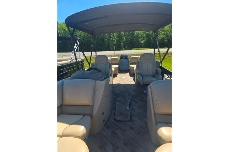 Slide: The Image of 2018 Manitou 23 Encore SL pontoon boat interior with beige seating and canopy. - 8