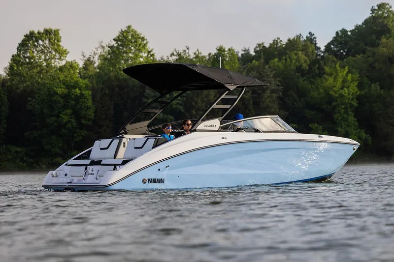 Slide: The Image of Manufacturer Provided Image: 2026 Yamaha Boats 252SE cruising on a serene lake with lush green trees in the background. - 16