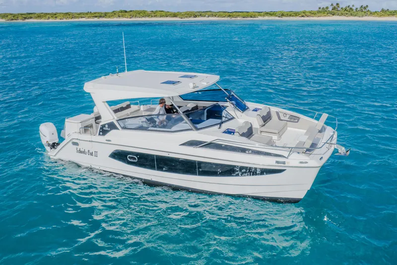 Slide: The Image of 2023 Aquila 36 Sport boat cruising on clear blue water near a tropical island. - 3
