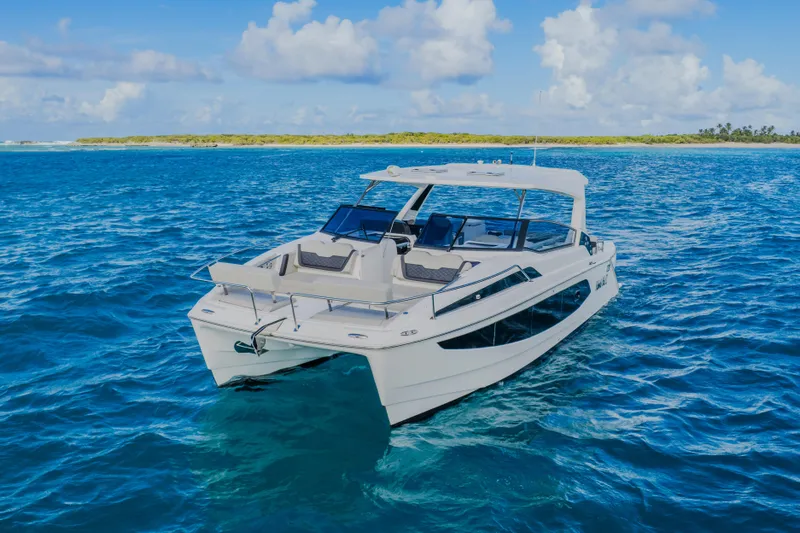 Slide: The Image of 2023 Aquila 36 Sport catamaran cruising on clear blue ocean waters. - 8